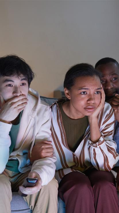 Groep mensen kijkt angstig richting tv