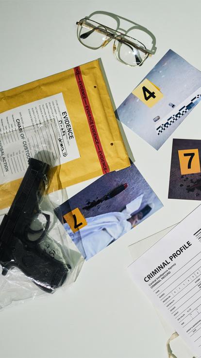 Genummerde bewijsstukken in een strafzaak, waaronder een vuurwapen, foto's en een bril
