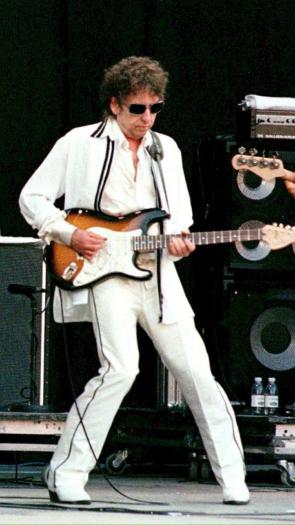 Bob Dylan speelt gitaar met twee bandleden op een podium in 1998
