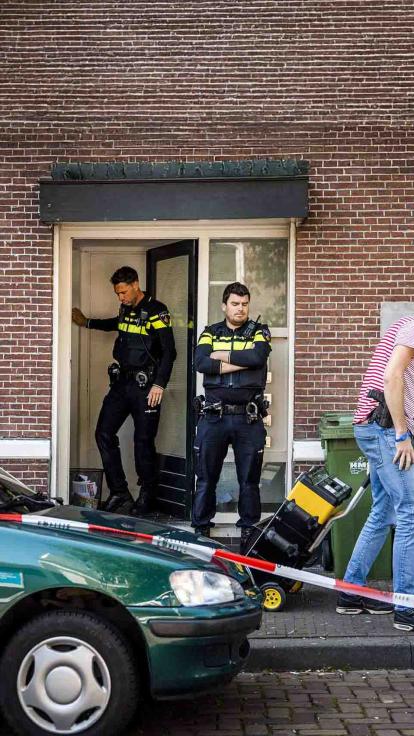 Politieagenten doorzoeken een huis.
