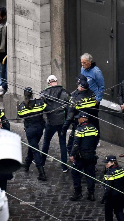 Een man wordt opgepakt door de politie.