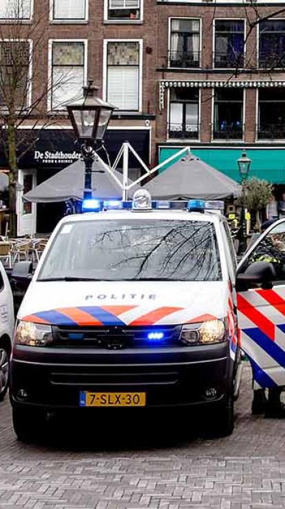 Politieauto staat stil met sirenes aan.