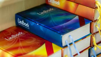 Stapels liedboeken in een protestantse kerk