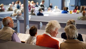 Kerkgangers wonen een kerkdienst bij in een protestantse kerk
