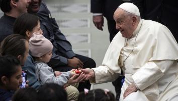 Paus Franciscus groet gelovigen in een hal in Vaticaanstad