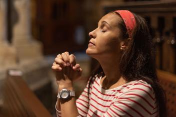 een vrouw bidt in de kerk