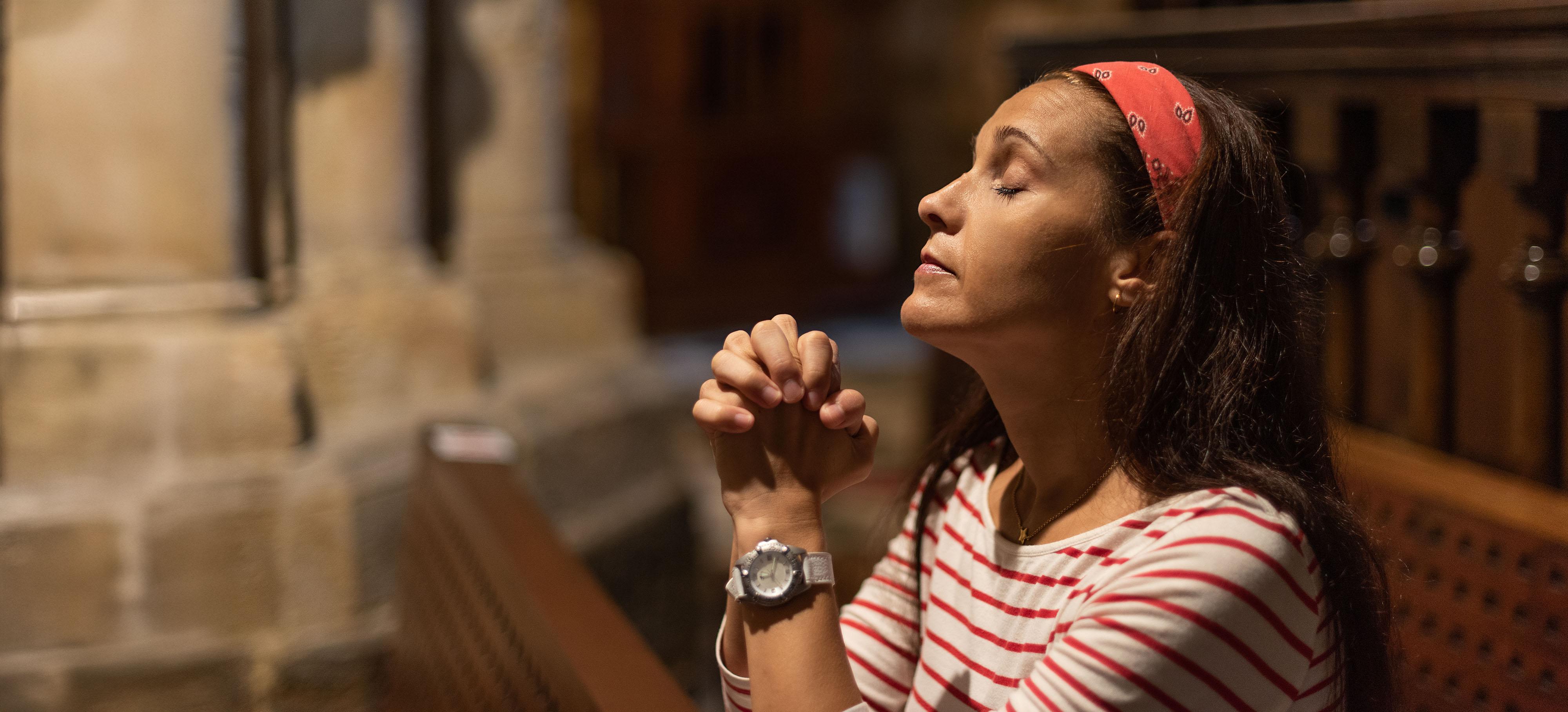 een vrouw bidt in de kerk