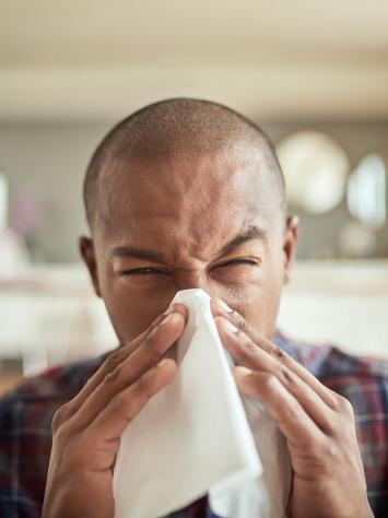 iemand snuit zijn neus in een tissue