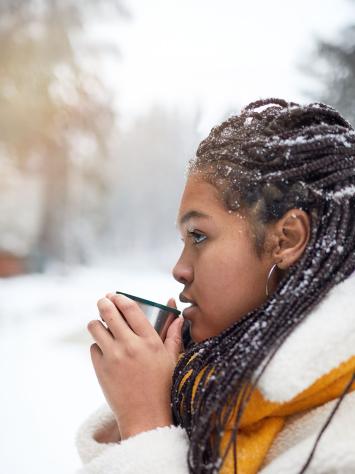 iemand drinkt een kopje thee in de kou buiten