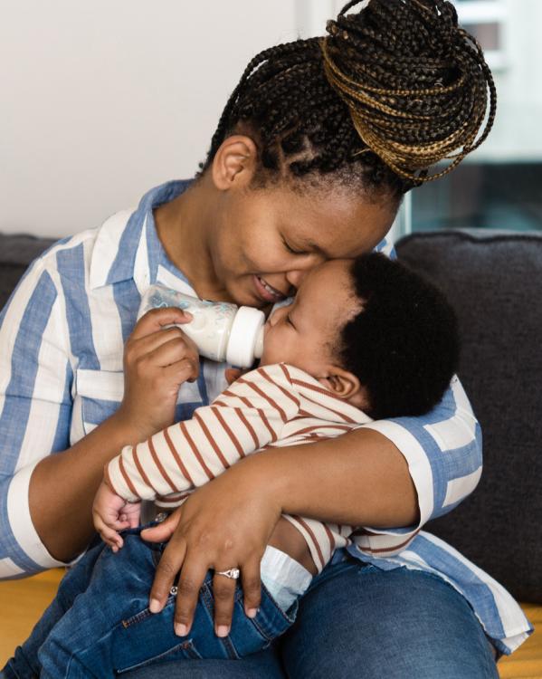een moeder geeft haar baby een flesje