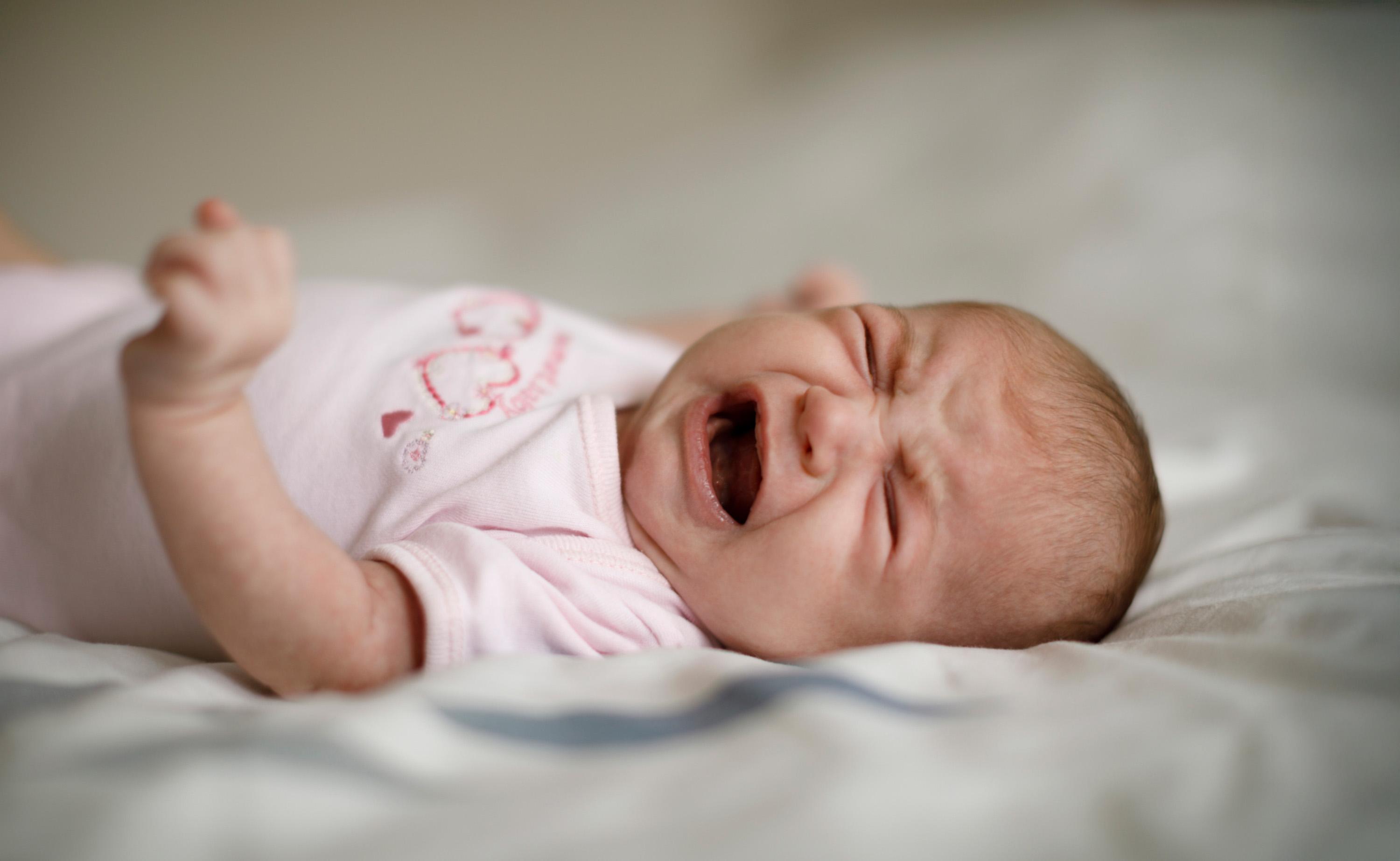een huilende baby op een lakentje