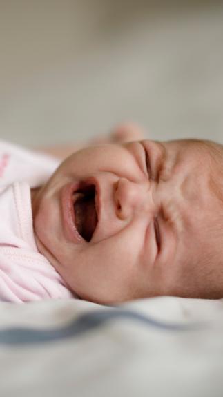 een huilende baby op een lakentje