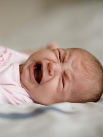 een huilende baby op een lakentje