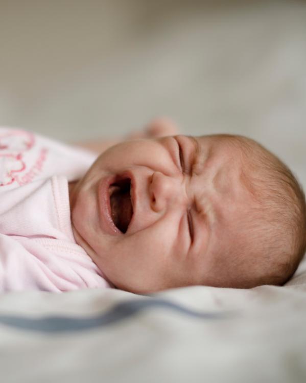 een huilende baby op een lakentje