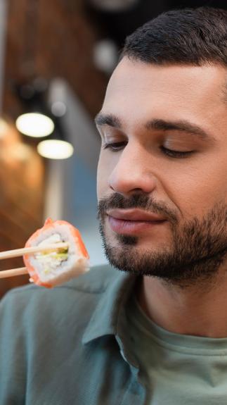 een man probeert sushi uit