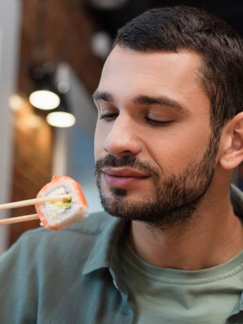 een man probeert sushi uit