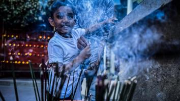 Een jongen brandt wierook tijdens een Vesakviering