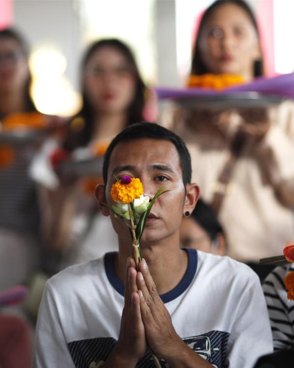 Thaise boeddhisten bidden voor een Boeddhabeeld 