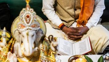 Een Hindoepriester (Pandit) leest voor uit een van de geschriften tijdens een ceremonie (puja)