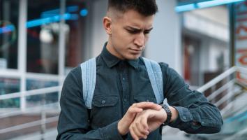 iemand kijkt verward naar zijn horloge