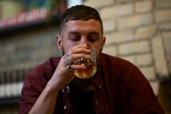 Jongen neemt slok uit een borrelglas