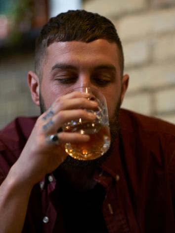 Jongen neemt slok uit een borrelglas