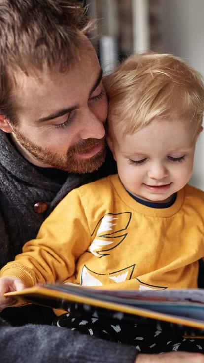 Een vader en zoon kijken in een boek