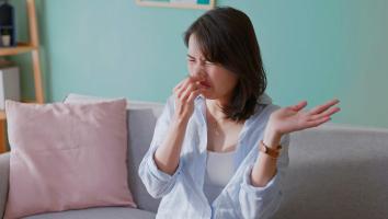 Vrouw knijpt neus dicht en trekt een vies gezicht