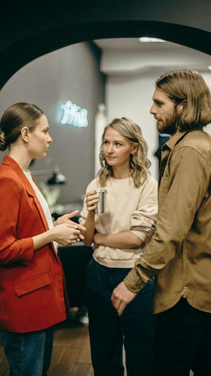 drie mensen voeren een gesprek
