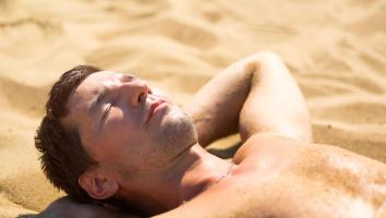 een man aan het zonnen op het strand