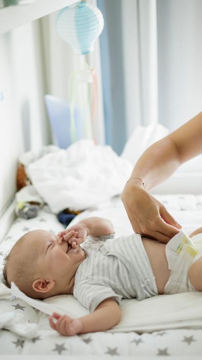 iemand verschoont de luier van de baby