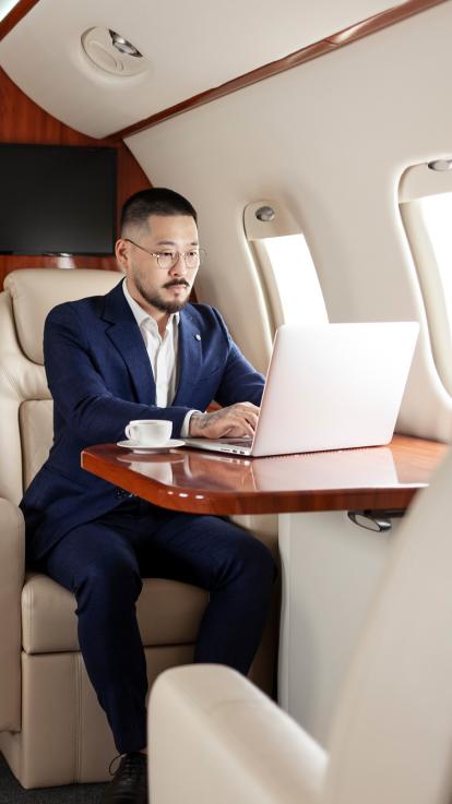 Man aan het werk op laptop in een privéjet