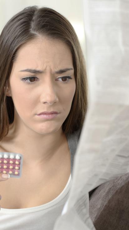 iemand leest de bijsluiter van de pil