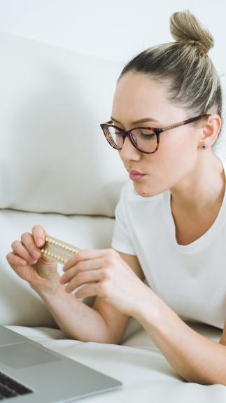 iemand kijkt bedenkelijk naar een pillenstrip