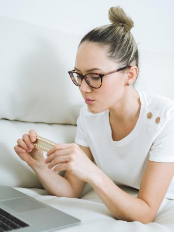 iemand kijkt bedenkelijk naar een pillenstrip