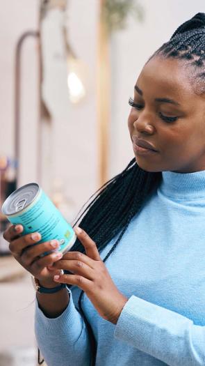 iemand kijkt bedenkelijk naar een blik groenten