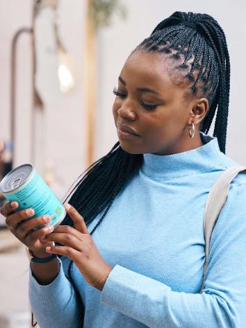 iemand kijkt bedenkelijk naar een blik groenten