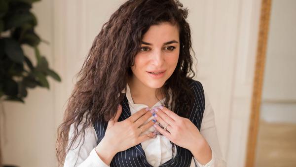 iemand praat met de handen op haar borst