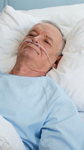 een verpleegkundige helpt een patiënt in een ziekenhuisbed