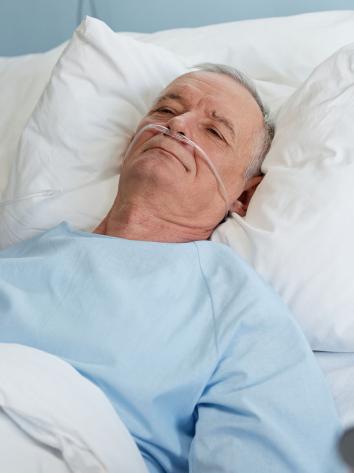 een verpleegkundige helpt een patiënt in een ziekenhuisbed