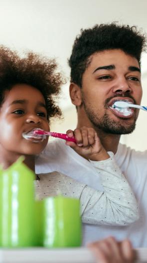 Vader en kind poetsen samen tanden