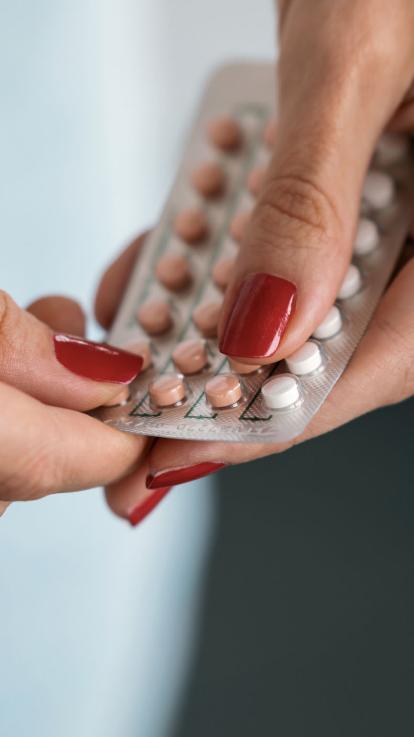 iemand pakt pilletjes uit een pillenstrip