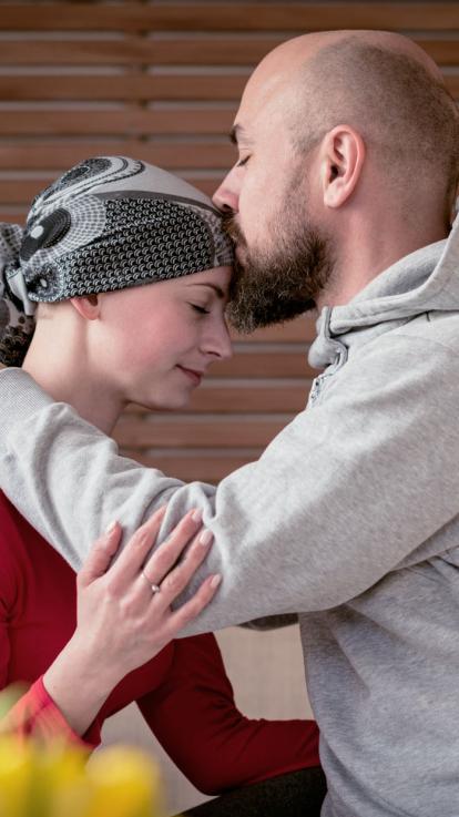 een man geeft zijn vrouw een kus op haar voorhoofd