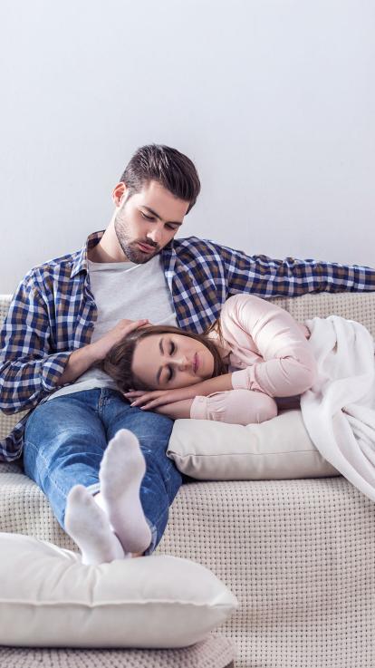 een vrouw slaapt op de schoot van haar vriend op de bank