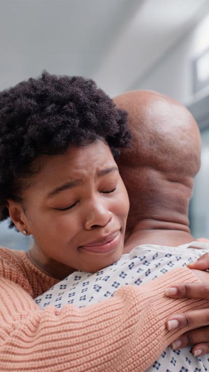 een vrouw knuffelt haar zieke man