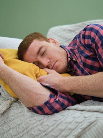 een vermoeide man slapend op de bank