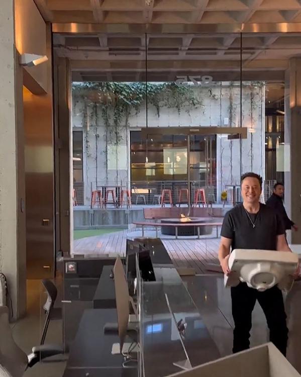 Musk loopt met een wasbak het hoofdkantoor van Twitter binnen na zijn overname.