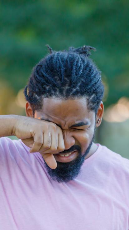 een man wrijft in zijn jeukende ogen