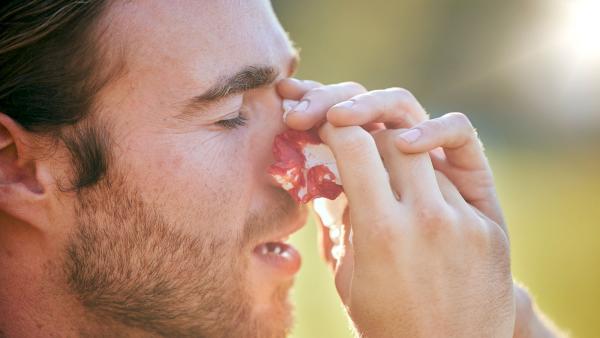 een man met een bebloed zakdoekje bij zijn neus