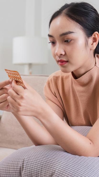 een vrouw kijkt naar een pillenstrip